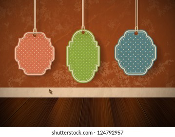 Three vintage die-cut paper labels hanging over an old weathered wall background - vector