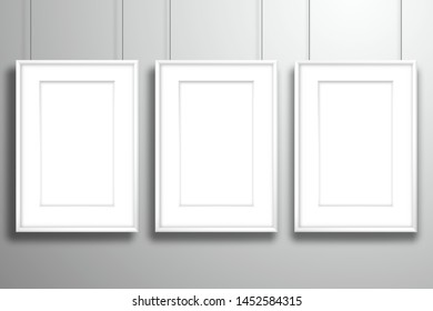 Three white blank paintings with passe-partout hanging on the strings. Mockup for gallery design with shadow