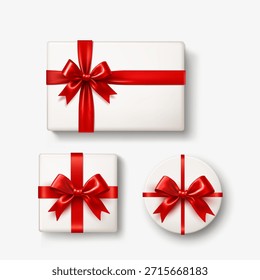 Three white gift boxes with shiny red ribbons and bows isolated on white background.