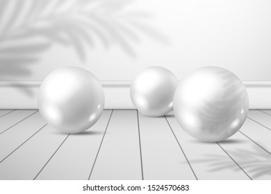 Three white shiny balls on a plank floor. A shadow of palm tree leaves on a white wall behind