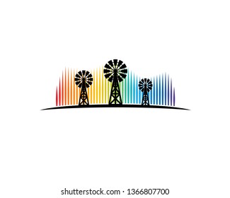 three windmill stands on the ground in front of aurora borealis
