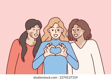 Three women with vitiligo syndrome are smiling demonstrating heart gesture as sign of self-love. Girl friends congratulate on vitiligo day calling for tolerance to people with depifmentation of skin