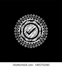 tick icon inside chalk emblem written on a blackboard