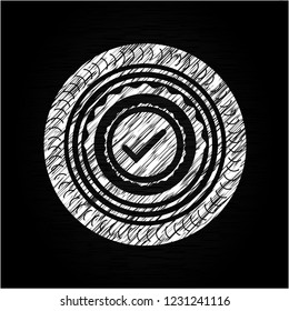 tick icon inside chalkboard emblem on black board