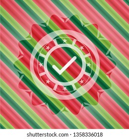 tick icon inside christmas emblem.