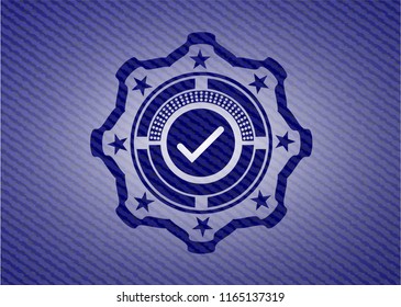 tick icon inside emblem with jean background