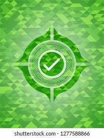 tick icon inside green emblem with triangle mosaic background