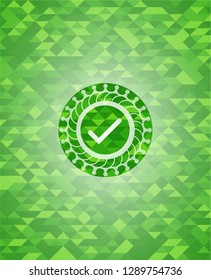 tick icon inside green mosaic emblem
