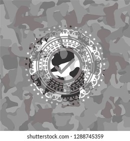 tick icon inside grey camouflaged emblem