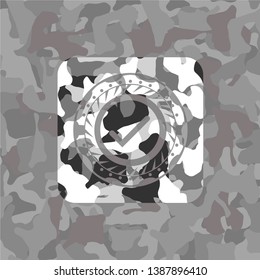tick icon inside grey camouflaged emblem