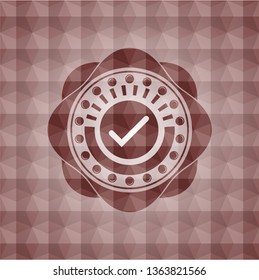 tick icon inside red seamless emblem with geometric pattern background.