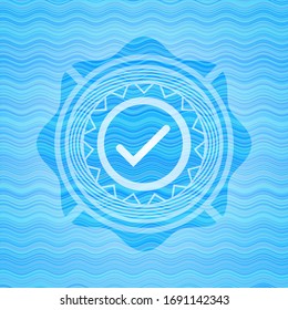 tick icon inside water concept emblem.