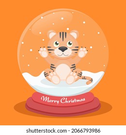 Tiger cub catches snow inside a glass ball