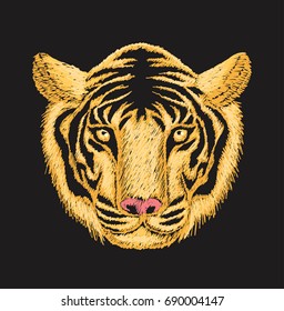 Tiger face embroidery design with yellow and orange threads on black cloth.