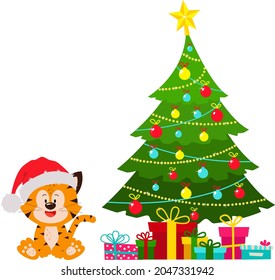 A tiger in a hat is sitting at the Christmas tree with gifts. The Year of the Tiger. Happy New Year and Merry Christmas. The new year is 2022.