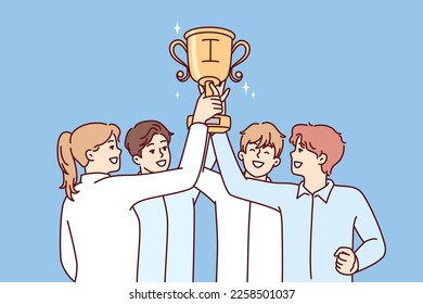 Tight-knit team of office workers raises golden cup over heads rejoicing at best sales results. Men and women hold first place prize after winning best startup competition