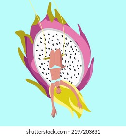 Tiny girl upside down on a swing against the background of a huge dragon fruit, pitaya, pitahiya, summer mood, summer vibes, organic, healthy food, vitamins.
