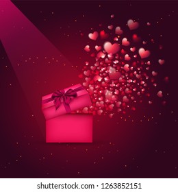 Pequeñas formas de corazón que salen de la caja de regalo sobre un brillante fondo marrón. Se puede usar como diseño de tarjetas de felicitación.