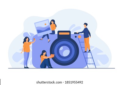 Tiny people and large photo camera isolated flat vector illustration. Cartoon characters making selfie and holding full picture. Photography courses and artistic occupation concept