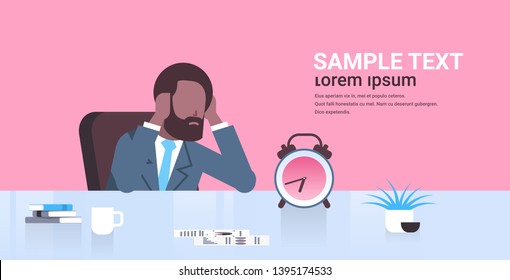 tired businessman holding head african american business man sitting workplace desk with alarm clock deadline time management concept male cartoon character portrait flat copy space