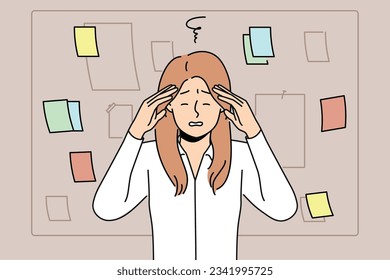 Tired businesswoman stands near blackboard with notes and grabs head after learning about overdue deadline. Woman manager feeling headache due to regular overtime caused by strict deadline