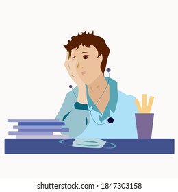 A tired doctor sits at a table with documents