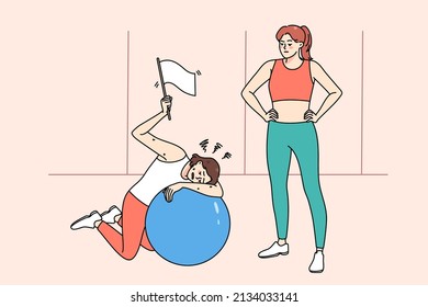 Tired woman rest lying on fitness ball after workout with personal trainer in sports club. Exhausted girl show white flag feel fatigue and weakness at sport training in gym. Sporty lifestyle. 