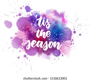 'tis the season - handwritten modern calligraphy lettering text on purple watercolor paint splash with stars and sparkles decoration. Christmas holiday concept illustration.