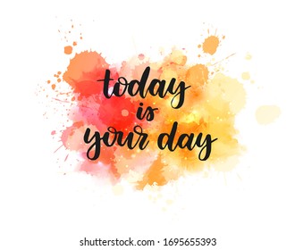 Today is your day - handwritten modern calligraphy inspirational text on multicolored watercolor paint splash. Orange and yellow colored background. 