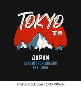 Tokyo, Japan typography graphics for slogan t-shirt with mountains and silhouette of city landscape. Tee shirt print with grunge and inscription in Japanese with the translation: Tokyo. Vector.
