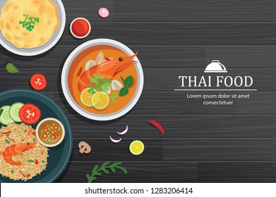 Tom yum kung in the bowl on black wood table top view. Thailand set food background.