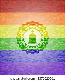 tombstone icon inside emblem on mosaic background with the colors of the LGBT flag