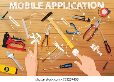 Tools on the wood table mobile application and hands pushing buttons