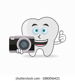 Tooth mascot character holding camera. vector illustration