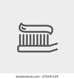 Toothbrush with toothpaste icon thin line for web and mobile, modern minimalistic flat design. Vector dark grey icon on light grey background.