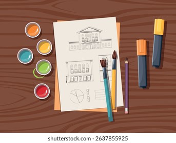 Top view of art workplace. Colored pencils, markers and paper with architectural sketch of a house facade on wooden table.