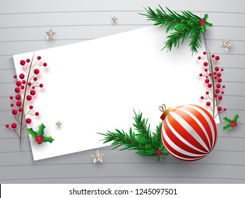 Top view of blank greeting card with realistic bauble, pine leaves and holly berries for merry christmas celebration concept.
