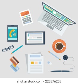 Top view of businessman's workplace with laptop, tablet, smartphone, credit cards, documents and cup of coffee