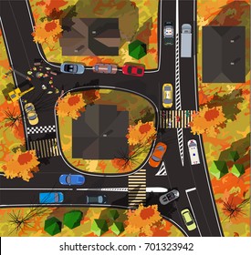 Top view crossroads in a small town. Workers are repairing the road in autumn with yellow leaves on trees
