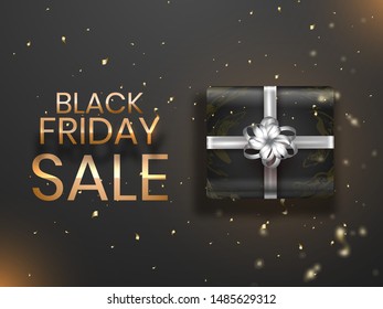 Top view of gift box on golden confetti party popper explosions for Black Friday Sale poster or banner design.