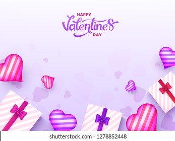 Top view of gift boxes with heart shapes decorated on purple background for Valentine's day celebration poster design.