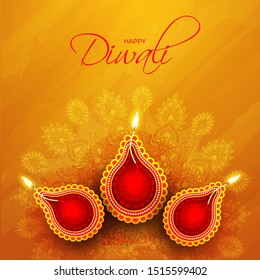 Top view of illuminated oil lamp (Diya) on orange mandala pattern background for Happy Diwali celebration concept.