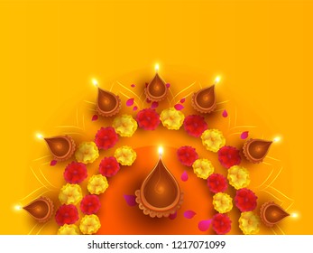 Top view of illuminated oil lamps decorated with flowers on orange background can be used as Happy Diwali greeting card design.