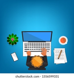the top view of a man who is working on a table front computer monitor