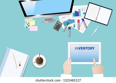 Top view of the office desk with office equipment. Manager is holding a tablet with inscription Inventory at the screen with free place for your another text. 