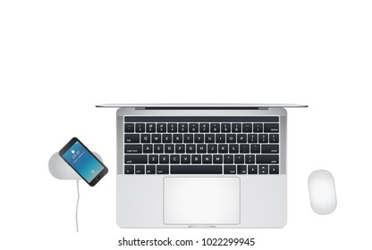 Top view of office desk with laptop, mouse and smartphone on wireless charging pad.Isolate on white background with copy space.