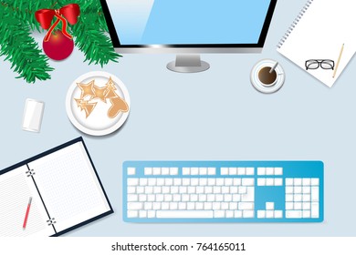 Top view of the office desk with twig of Christmas tree,  coffee cup, blank notebook, paper with pen, computer monitor and keyboard. 