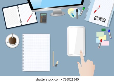 Top view of the office table. Hand is touching empty screen of the smart phone. Smart phone screen and blank notepad are ready for your text. All potential trademarks are removed.
