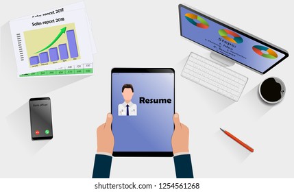 Top view on hands with laptop with Resume above desk with mobile, tablet and other business accessories. Modern business workplace