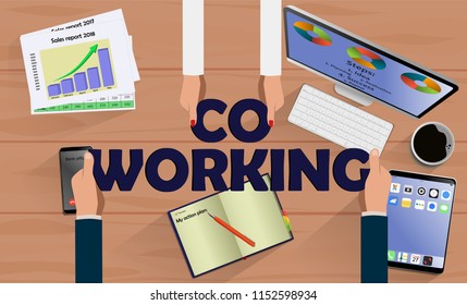 Top view on hands with letters COWORKING above desk with laptop,mobile, tablet and other business accessories Modern business workplace